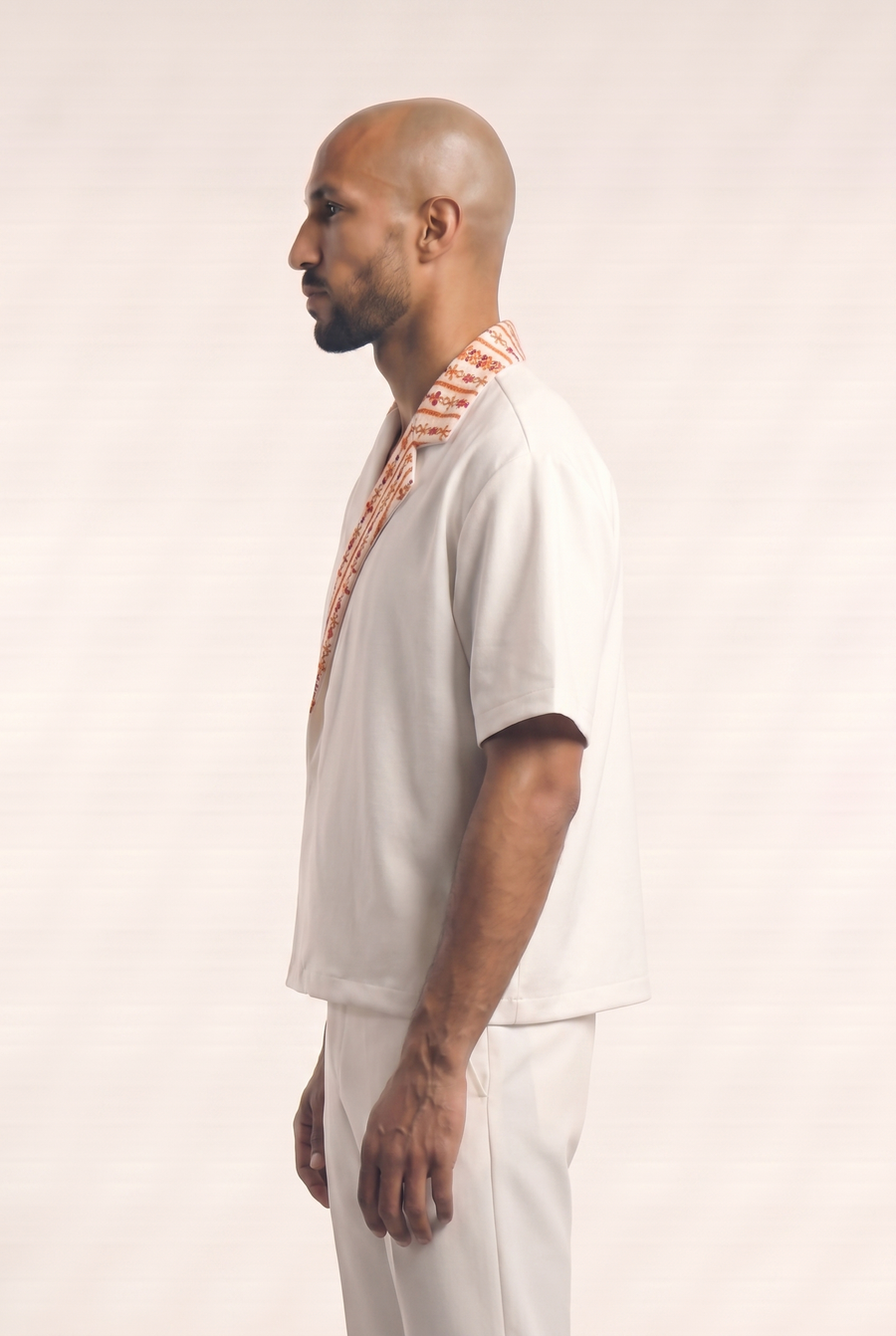 Side view of the white Big Day Stitches Shirt showing its asymmetric wrap silhouette