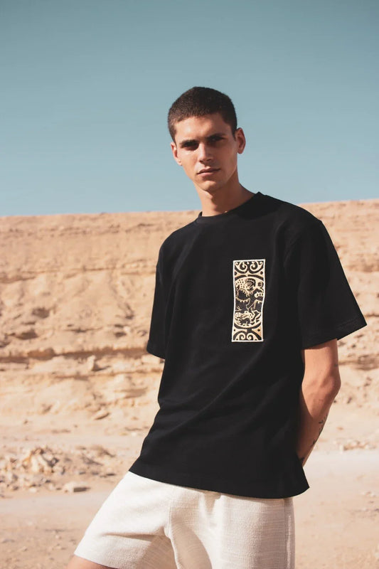 Black embroidered Warrior tee, close-up of embroidery detail