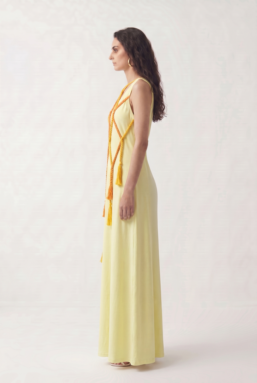 Side view of the Morning Bride Dress showing its floor-length silhouette and trailing tassels