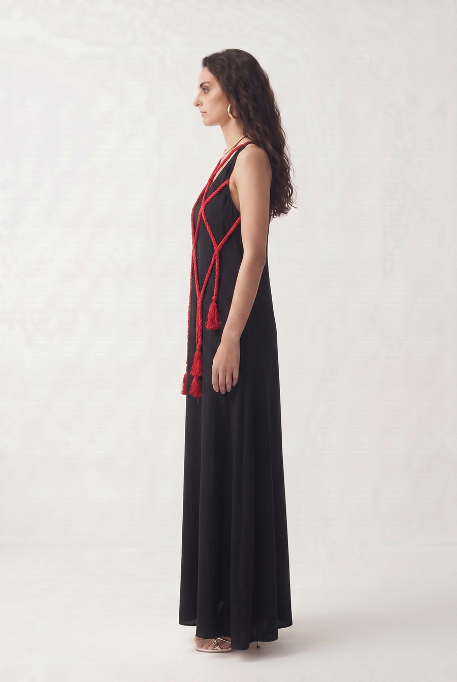 Side view of the Night Bride Dress showing its floor-length silhouette and trailing red tassels