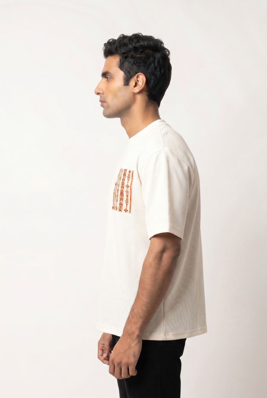 Side view of the white Siwi Stitches Tshirt showing its relaxed drop-shoulder fit