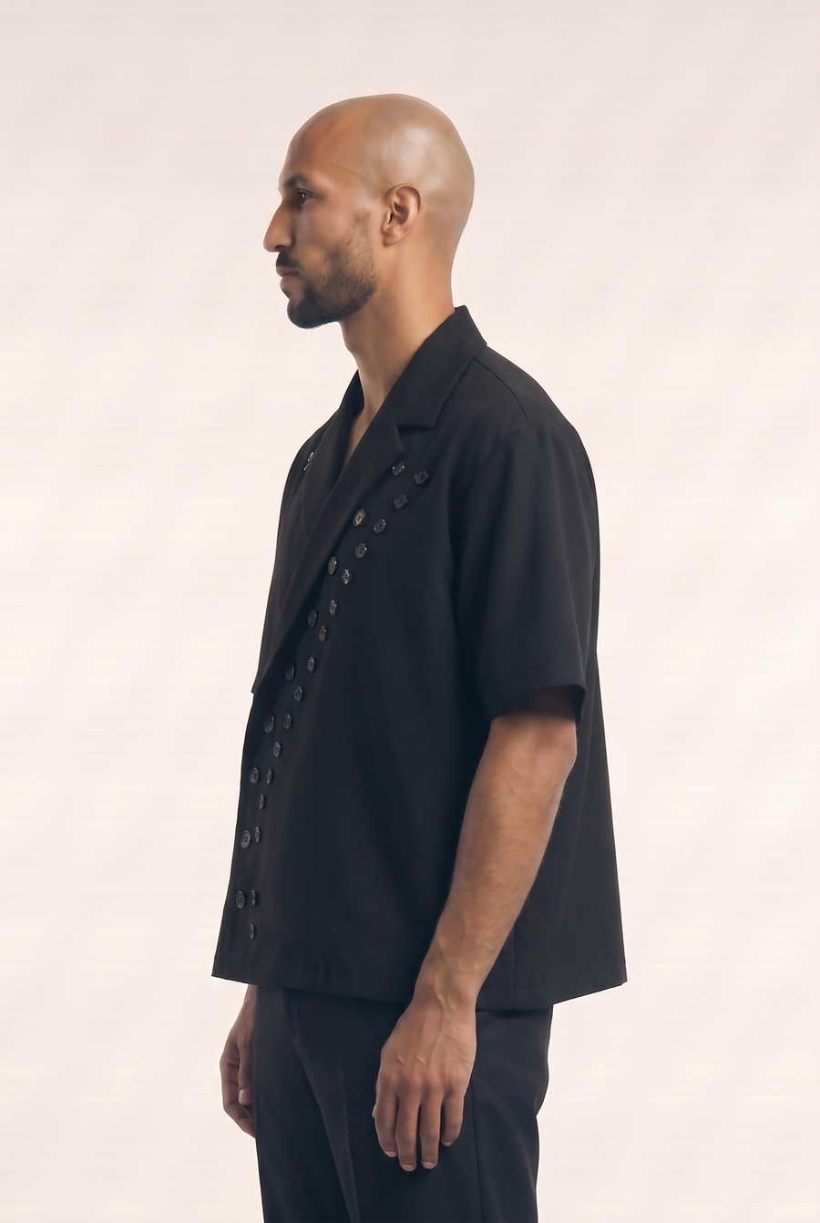 Side view of the black Big Day Buttons Shirt showing its lapel collar and wrap silhouette