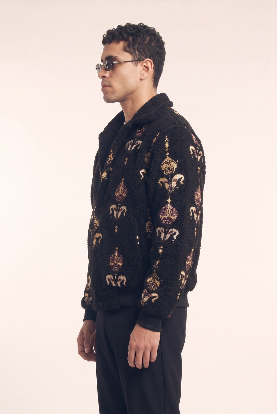 Black fleece jacket with Islamic art embroidery, side view.