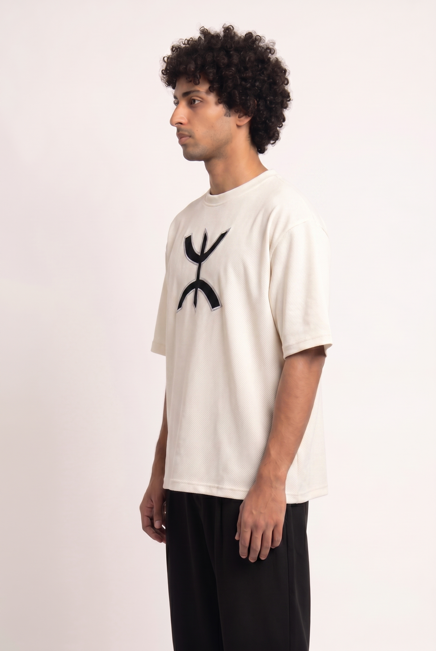 Side view of the white Free Spirit Tshirt showing its oversized, dropped-shoulder fit