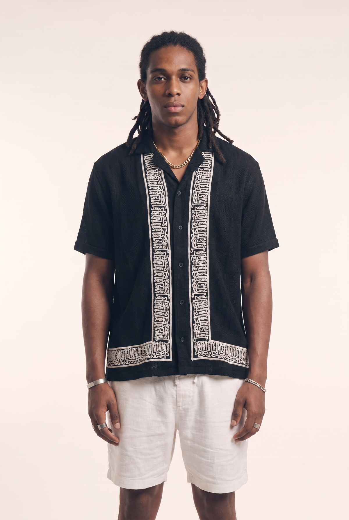 Black button-up shirt with embroidered calligraphy, front flat lay