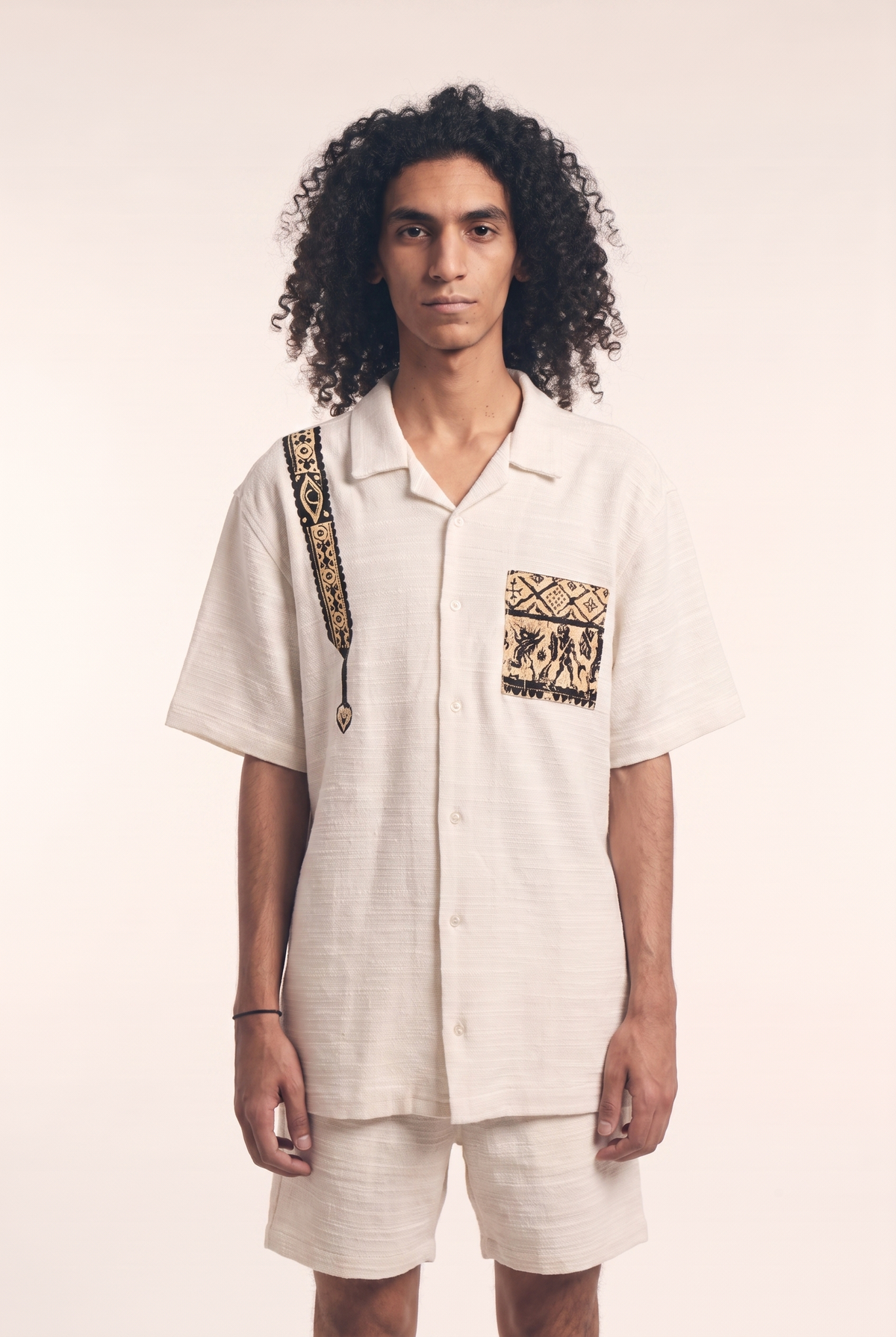Beige button-up shirt with embroidered Warrior motif, front flat lay