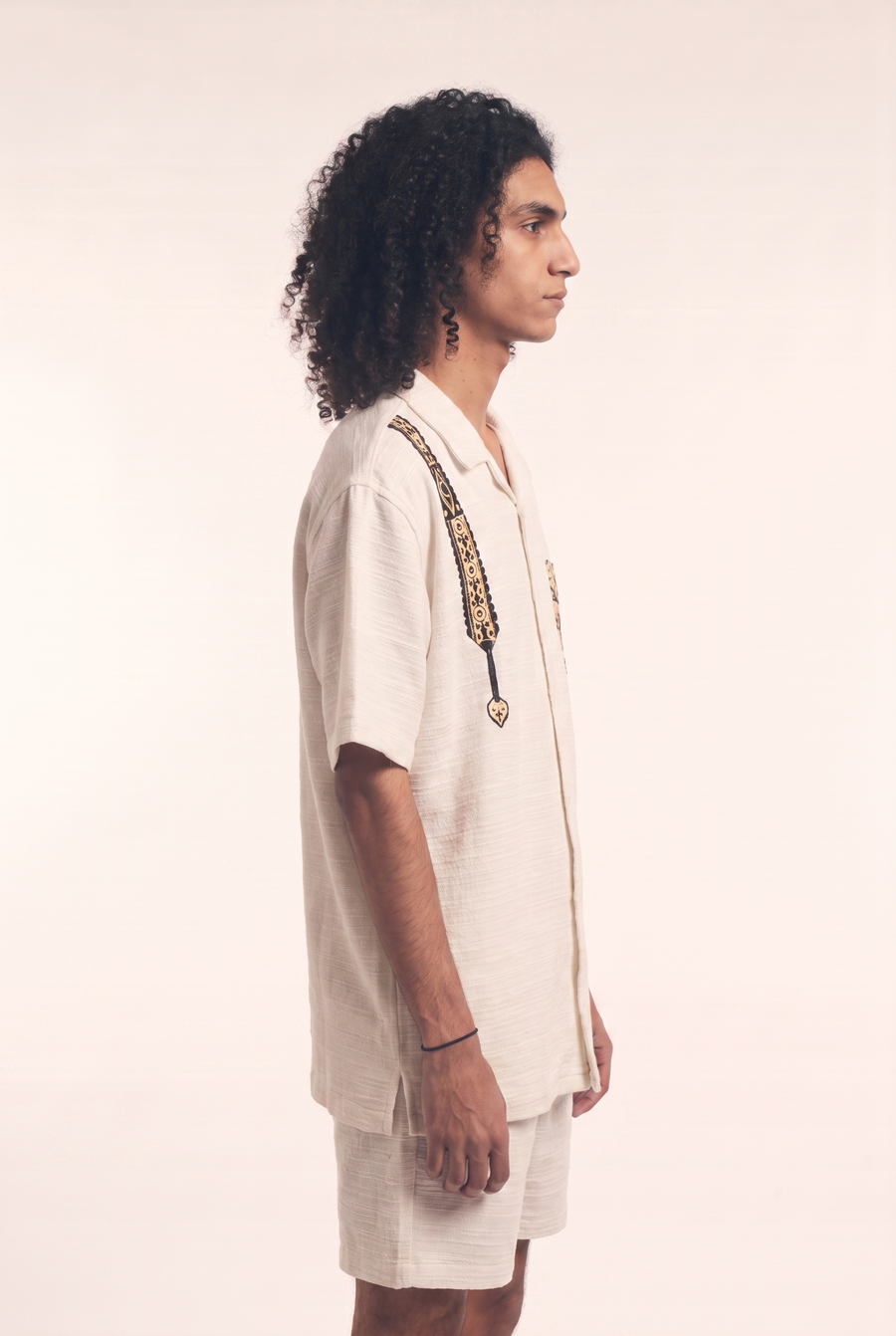 Beige button-up shirt with embroidered Warrior motif, side flat lay