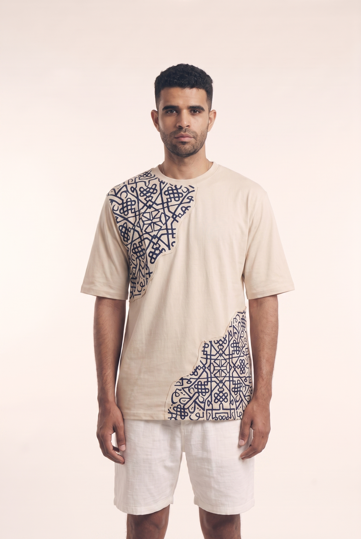 Beige tee with embroidered Islamic geometric pattern, front flat lay