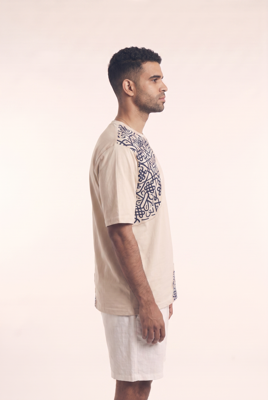 Beige tee with embroidered Islamic geometric pattern, side flat lay