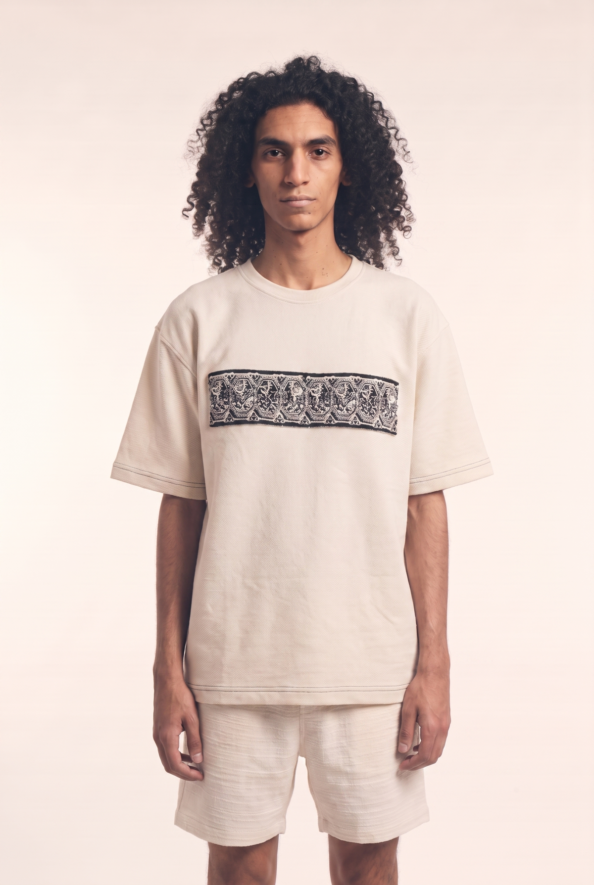 Beige tee with embroidered Lions motif, front flat lay