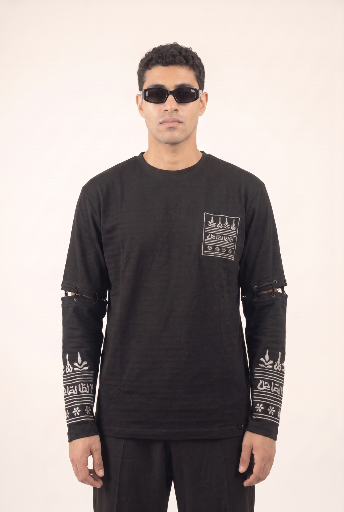 Black cotton shirt with silver Islamic-inspired embroidery on the lower sleeves, front view.