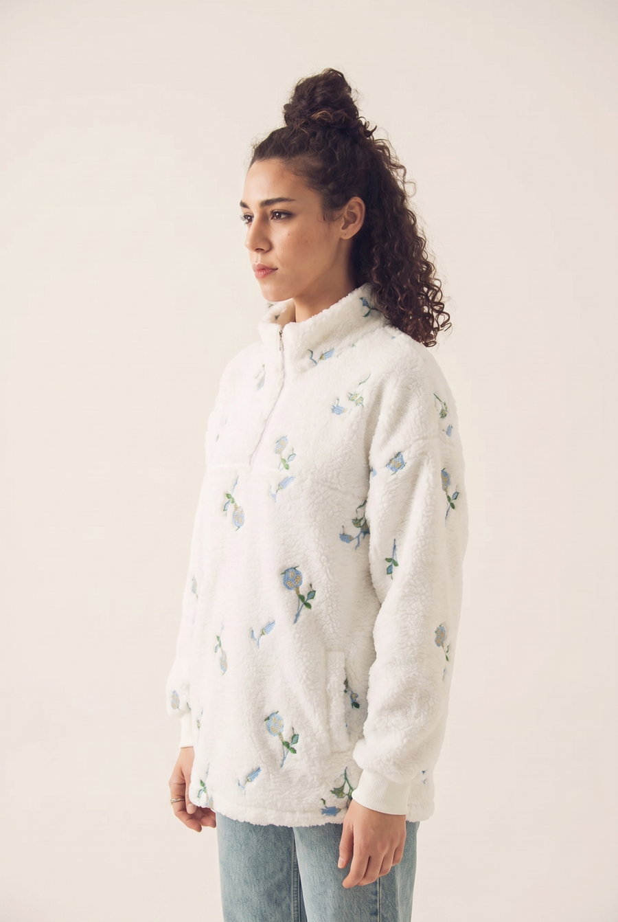 White sweatshirt with blue blossom embroidery, side view