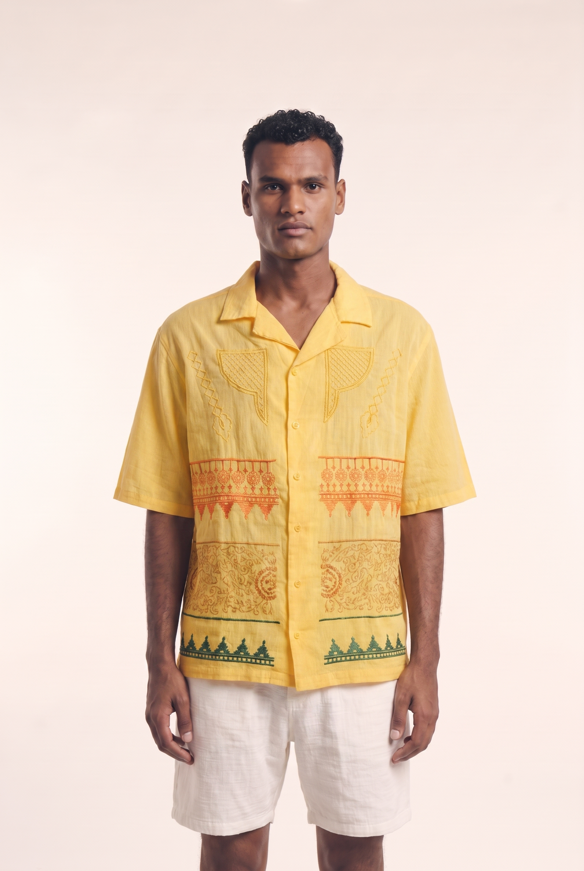 Yellow Nubian button-up shirt with heritage embroidered motifs, front view.